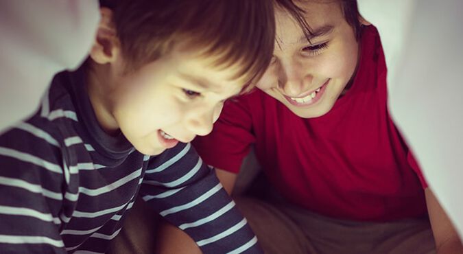 Niños jugando debajo de las cobijas