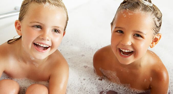 Hermanos felices tomando un baño de espuma