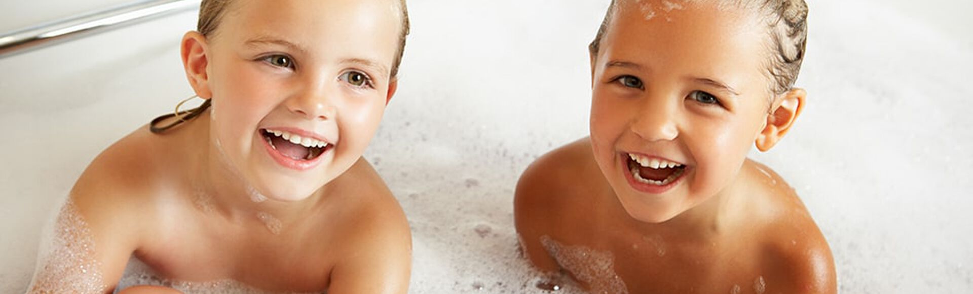 Hermanos felices tomando un baño de espuma